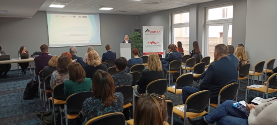Jeden Z Prelegentów Konferencji Stoi Przy Mównicy Przed Siedzącymi Uczestnikami