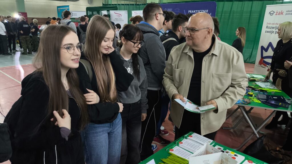 Doradca Rozmawia Z Uczestniczkami Targów Stojąc Przy Stoisku Wystawienniczym