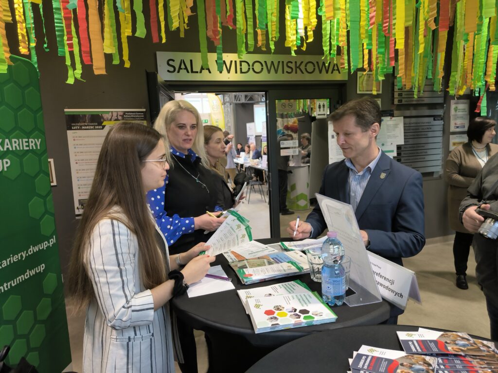Dwie Kobiety I Mężczyzna Stoją Przy Stoliku CIiPKZ DWUP