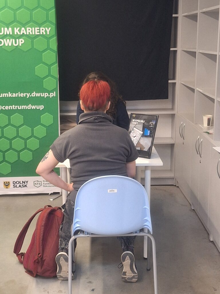 Doradczyni udzielająca porady klientce. Obie siedzą przy biurku.